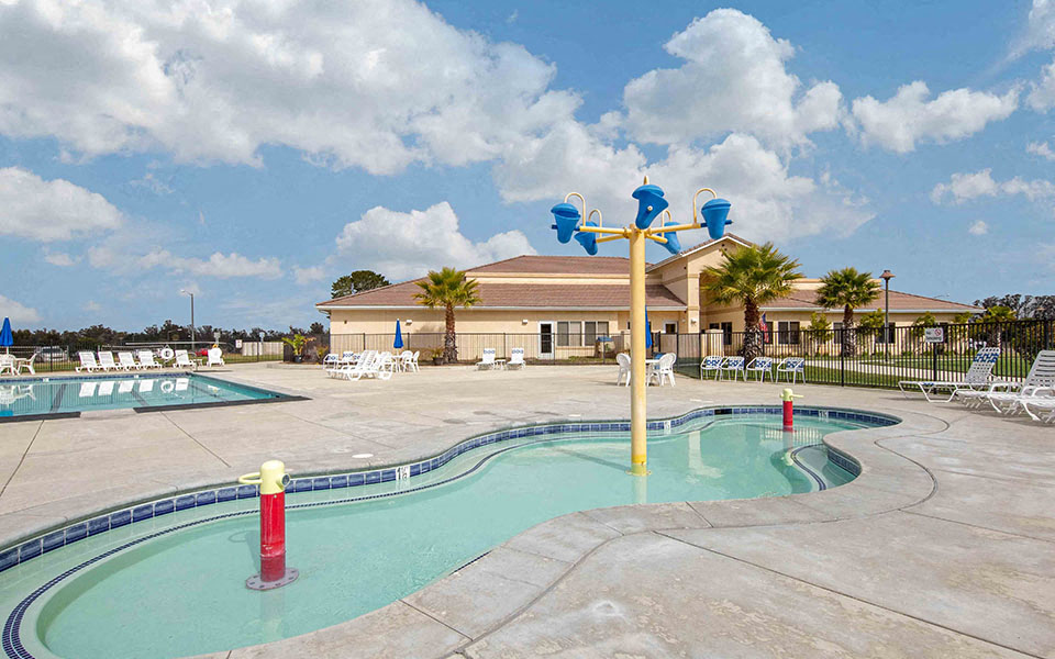 the swimming pool at the resort with a building in the background