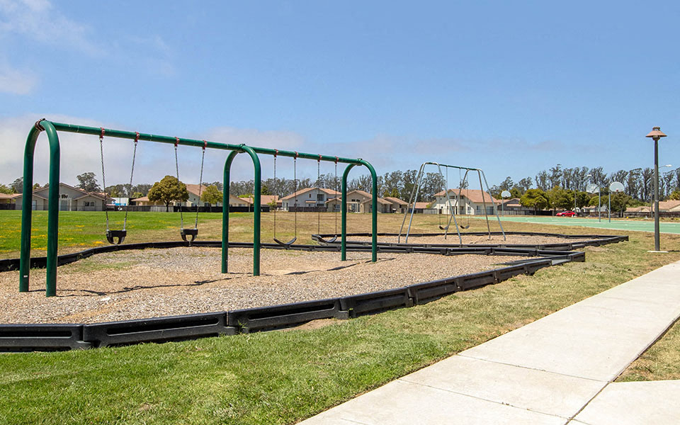 a playground with a swing set in a park
