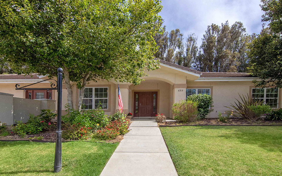 a sidewalk in front of a house with an flag