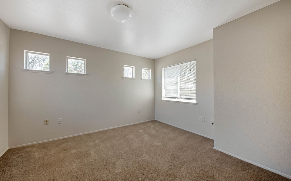 an empty room with carpet and a window