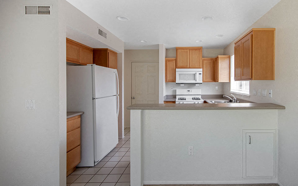an empty kitchen with a refrigerator and a sink
