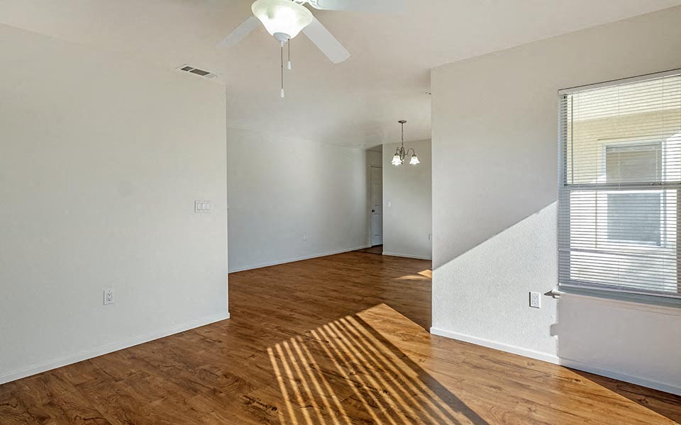 an empty room with a wood floor and a ceiling fan