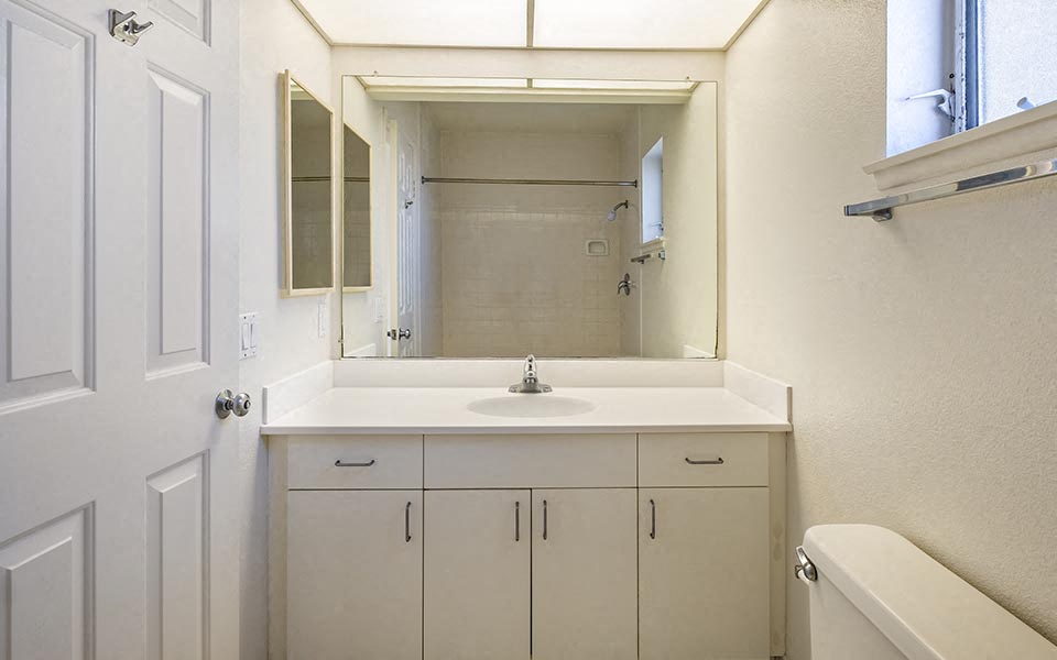 a white bathroom with a sink and a mirror