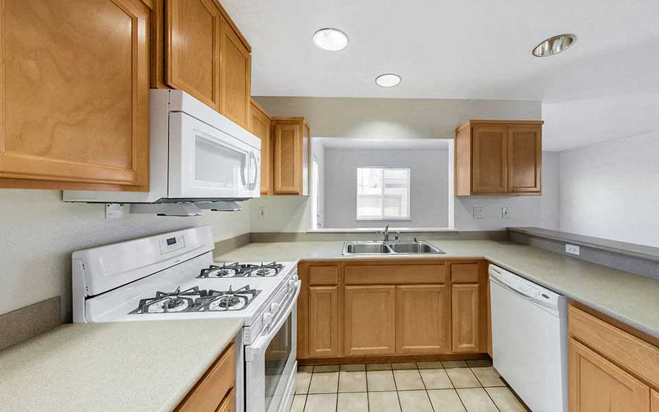 a kitchen with white appliances and wooden cabinets