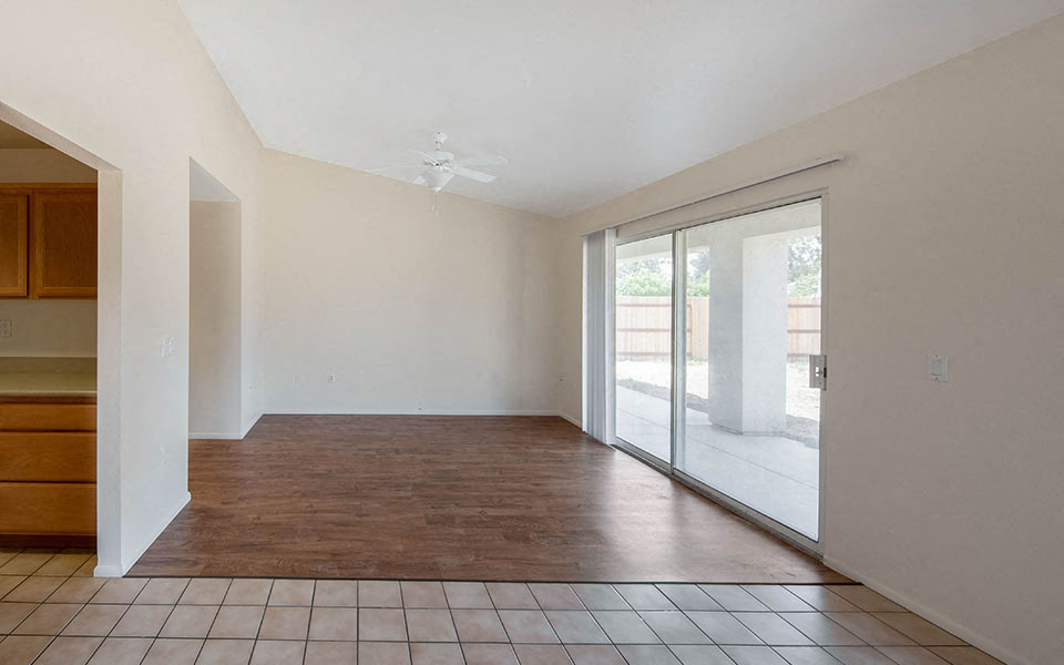 an empty living room with a sliding glass door to a patio