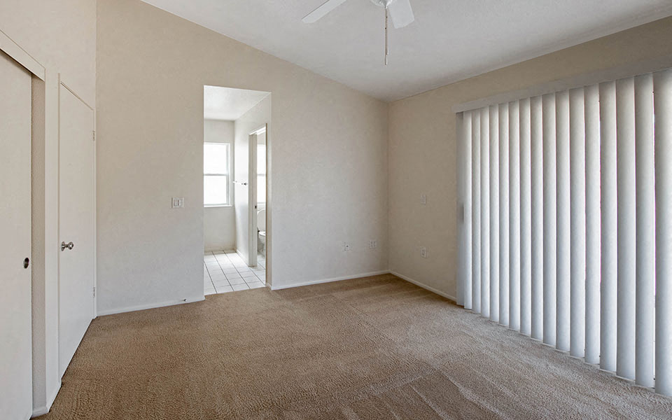 an empty living room with blinds on the window