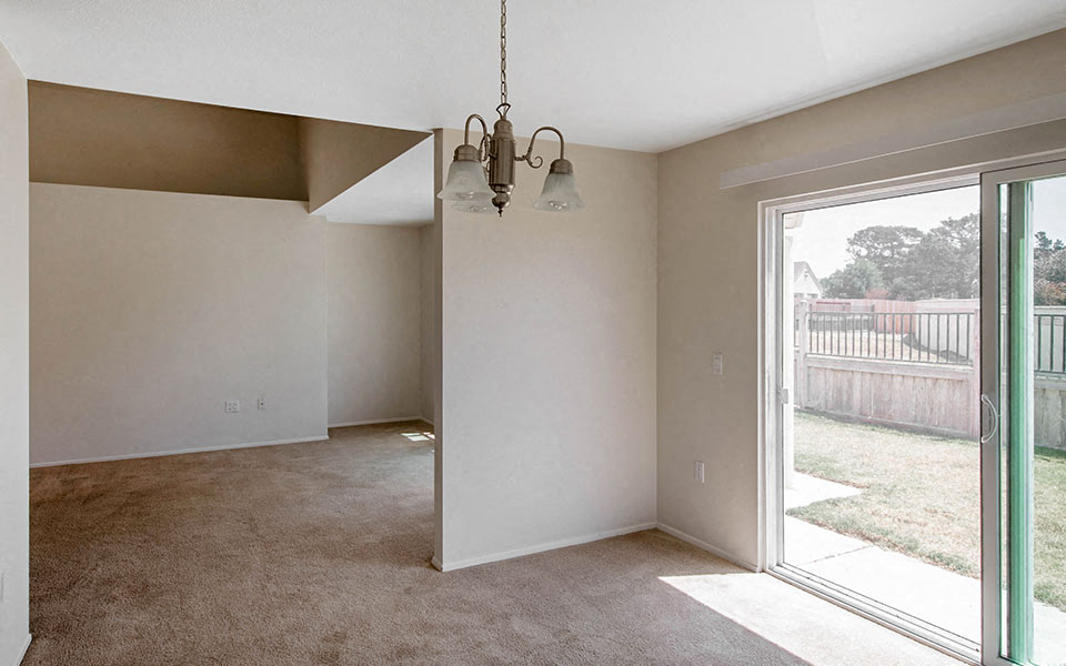 a living room with a sliding glass door and a chandelier