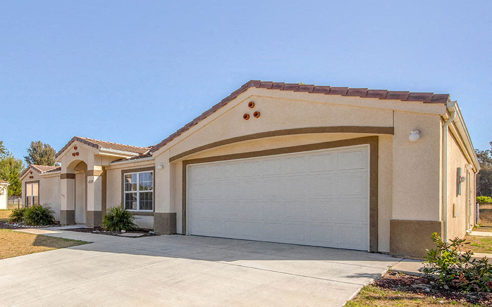 a beige house with a white garage door