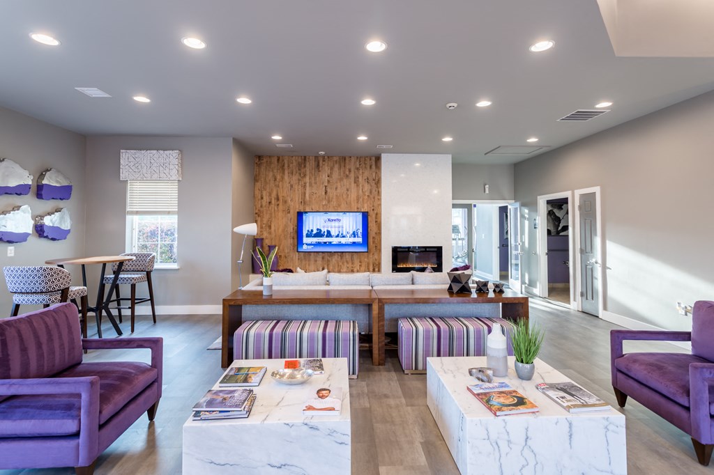 a living room with purple furniture and a television