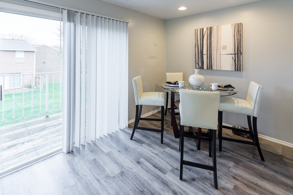 a dining room with a table and chairs and a sliding glass door