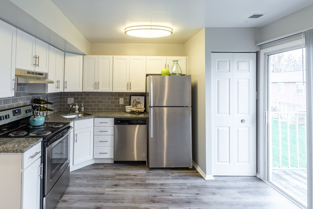 a kitchen with white cabinets and stainless steel appliances