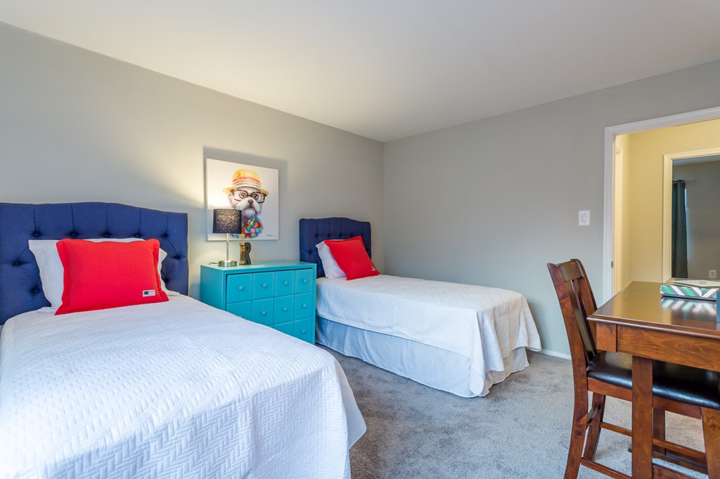 a bedroom with two twin beds and a desk with a chair