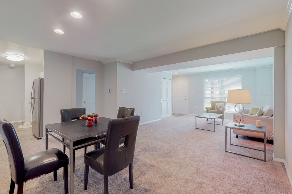 a living room and dining room with a table and chairs