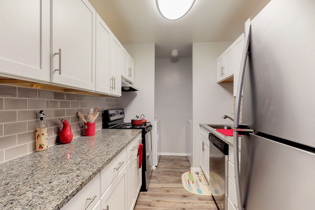 a renovated kitchen with white cabinets and granite counter tops