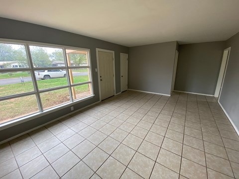the living room of an empty house with a large window