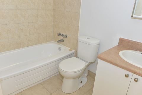 a bathroom with a toilet and a tub and a sink