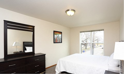 a bedroom with a bed and a dresser and a window