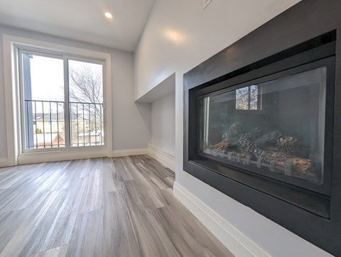 A room with a fireplace and a large window.