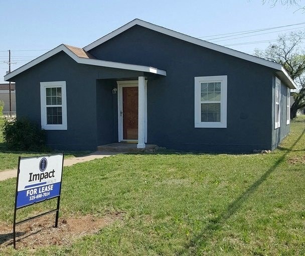 a blue house with a for sale sign in front of it