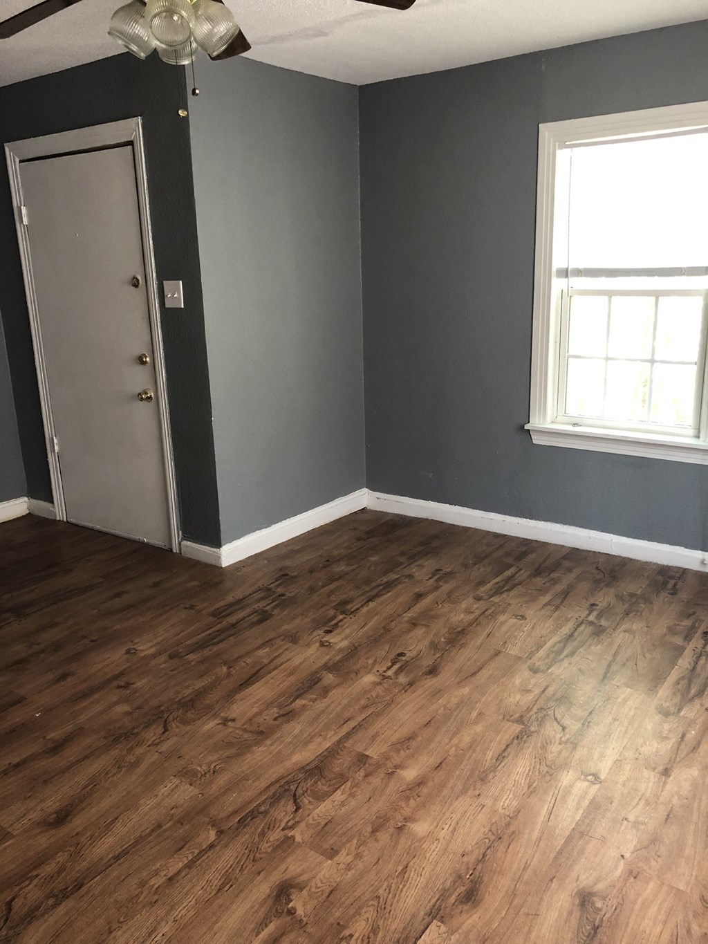 a living room with gray walls and a wooden floor
