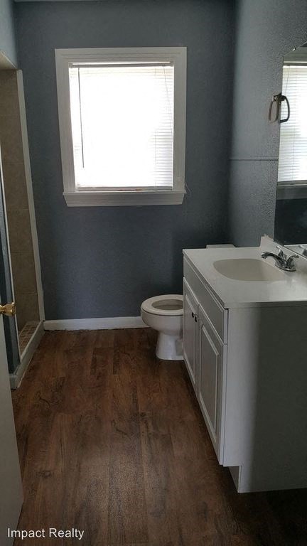 a bathroom with a toilet and a sink and a window