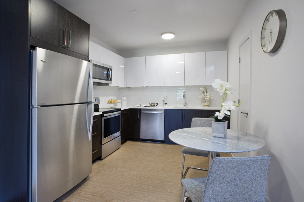 a kitchen with stainless steel appliances and a table and chairs