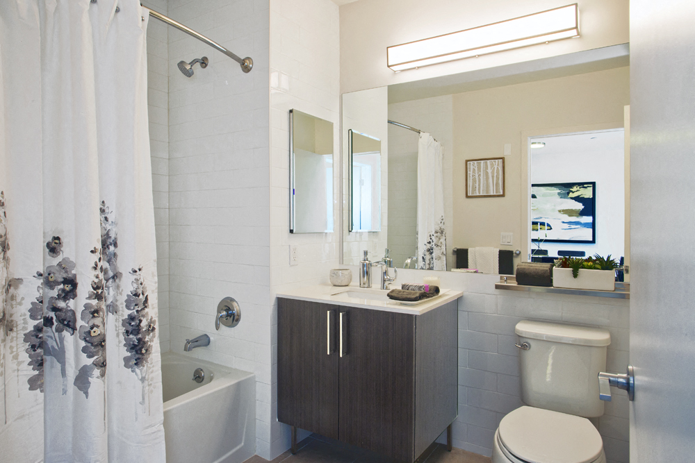 a bathroom with a toilet sink and shower and a mirror