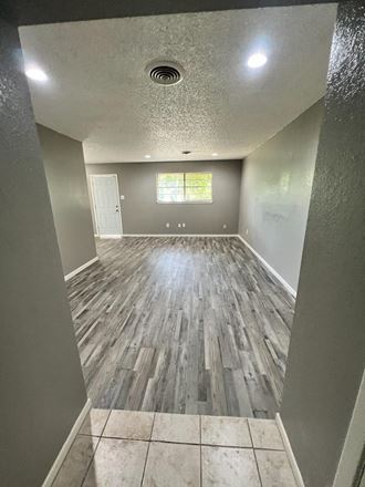 a empty living room with wood floors and grey walls