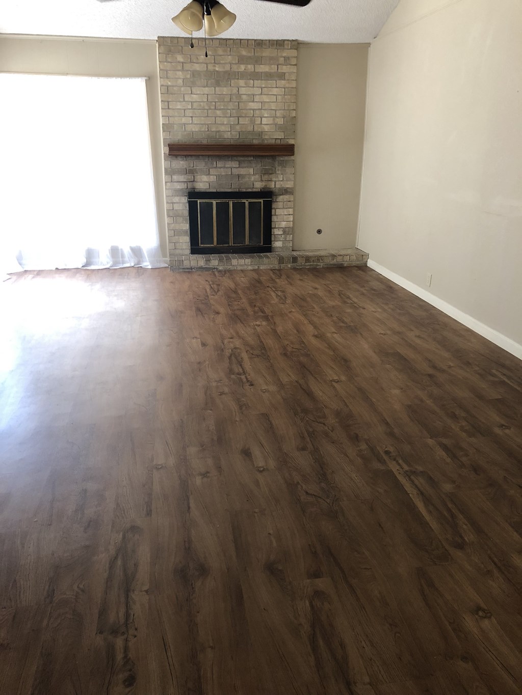 the living room has a hard wood floor and a fireplace