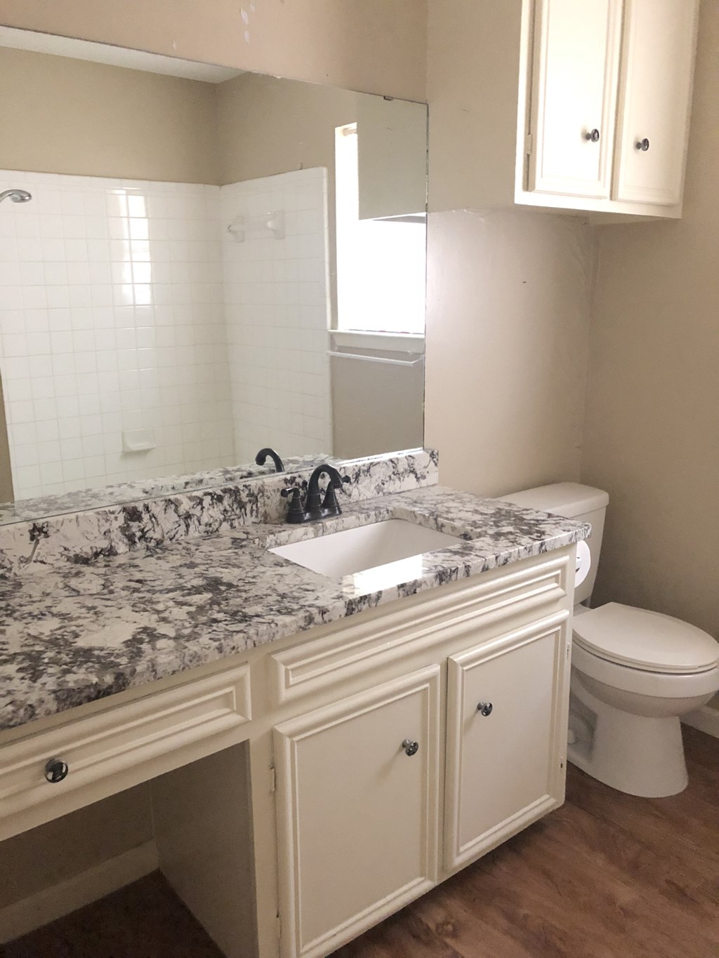 a bathroom with white cabinets and a sink and a toilet
