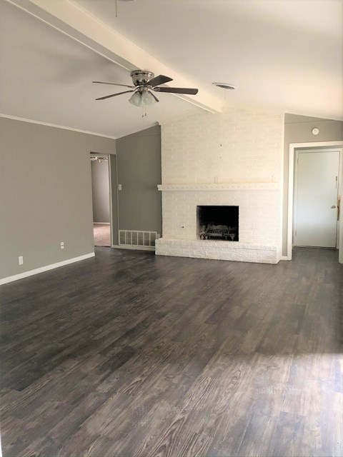 A room with a fireplace and a ceiling fan.