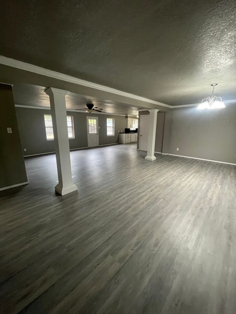 A spacious room with wooden flooring and a ceiling fan.