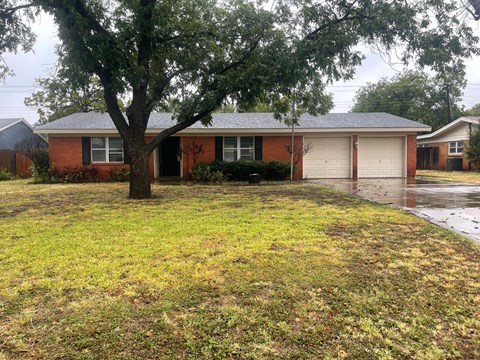 A house with a tree in front of it.