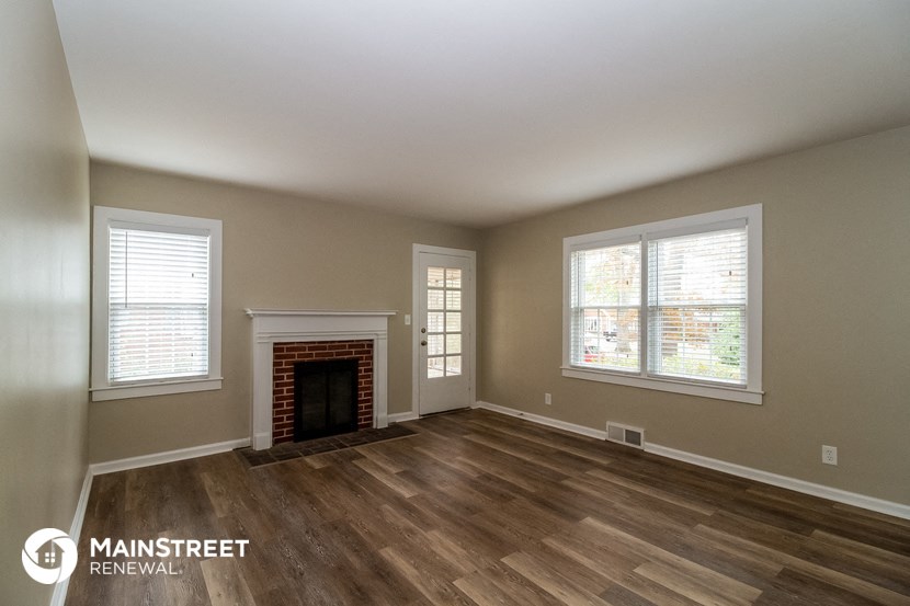 a living room with a fireplace and wooden floors