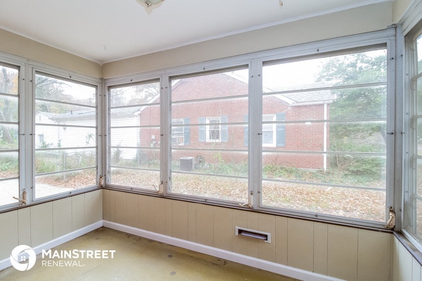 a living room with large windows and a view of a brick building