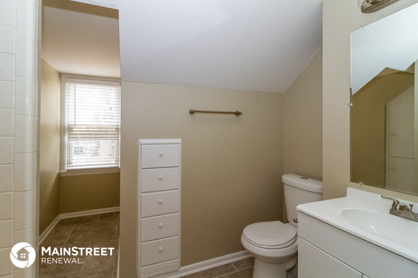 a bathroom with a toilet and a sink and a mirror