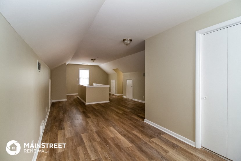 the living room and dining room of a home with wood flooring