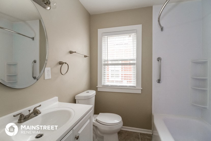 a bathroom with a toilet and a sink and a window