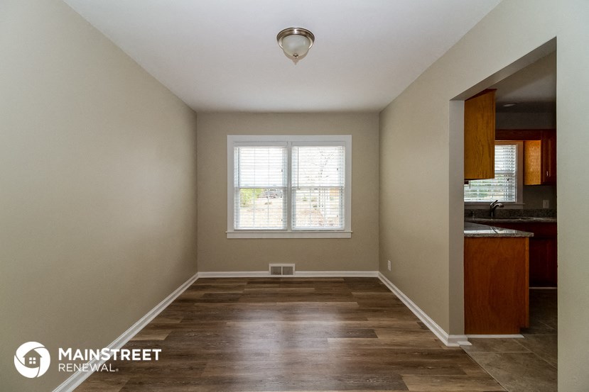 an empty room with wood floors and a window