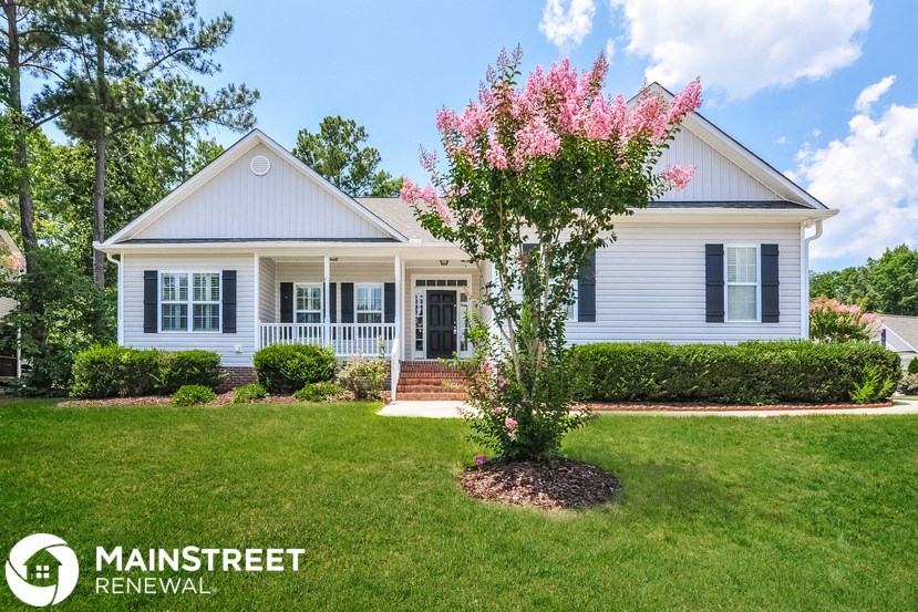 a white house with a tree in front of it