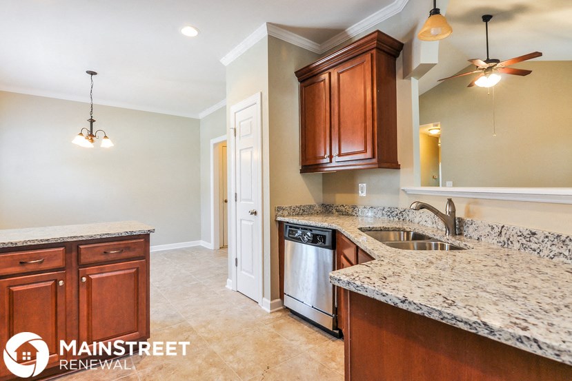 a kitchen with granite counter tops and wooden cabinets
