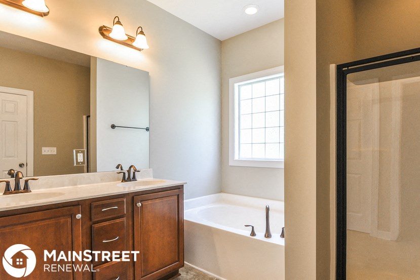 a bathroom with a tub and a sink and a mirror