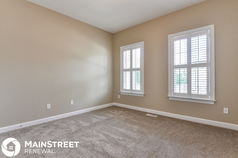 the master bedroom has a carpeted floor and two windows