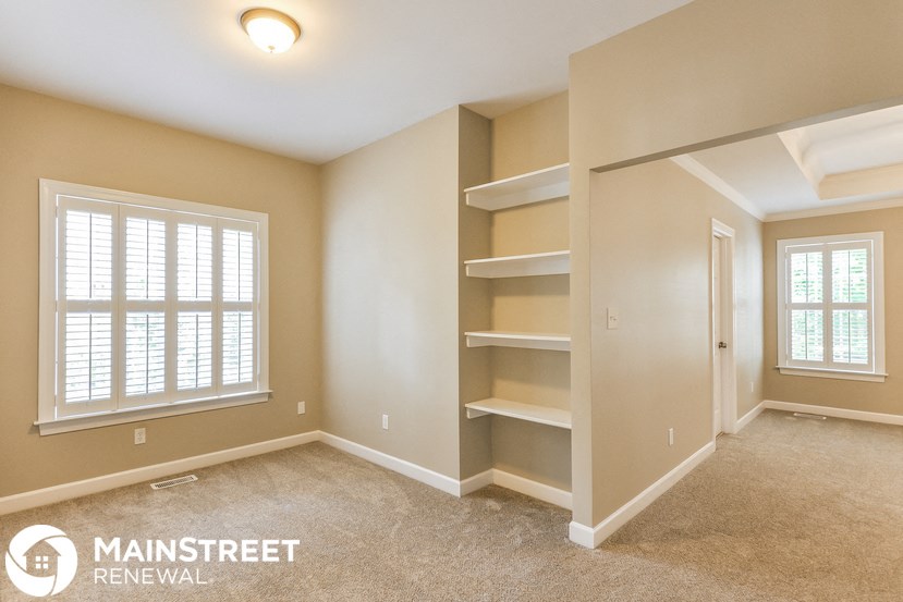the master bedroom has a large closet with shelves and a window
