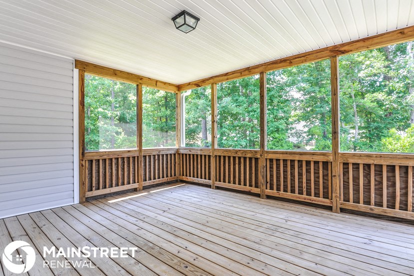 a screened porch with a view of the woods