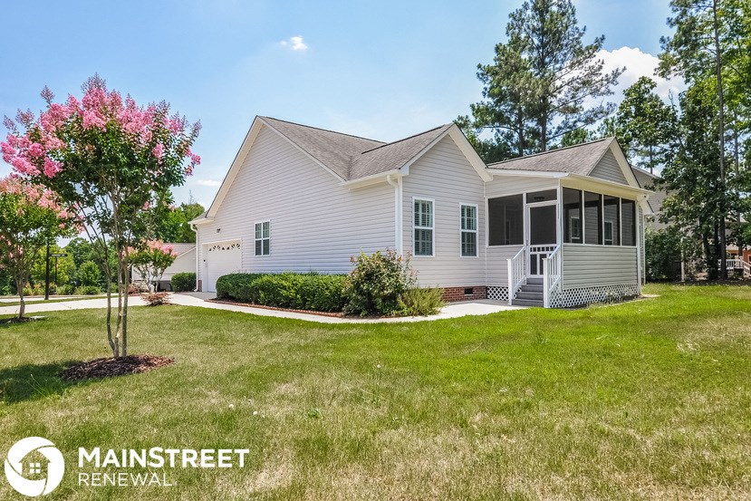 a white house with a lawn and a driveway