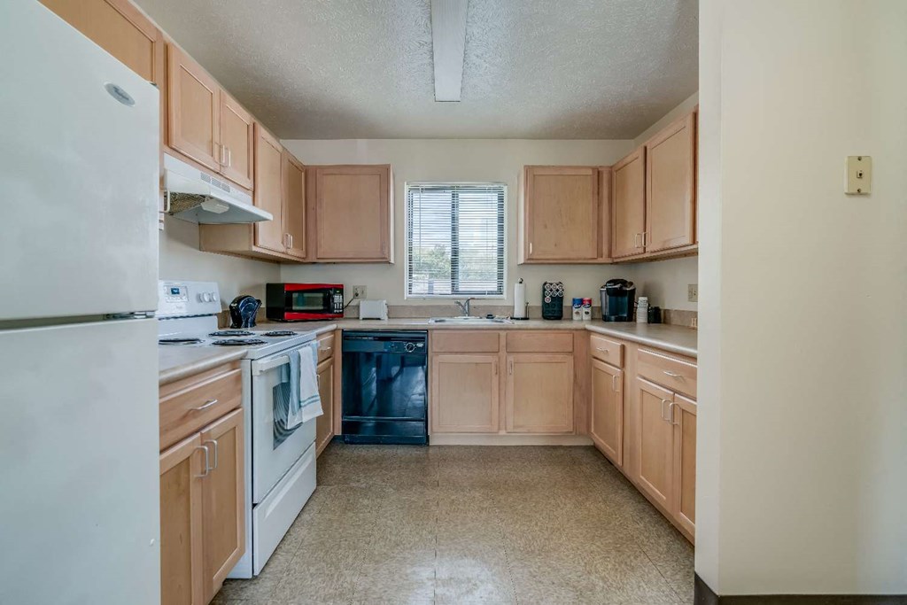 a kitchen with white appliances and wooden cabinets