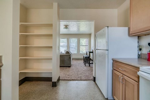 a kitchen with a refrigerator and a view of a living room