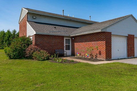 the front of a brick house with a white garage door
