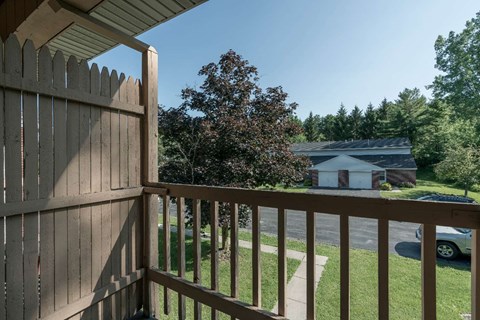 a view from a balcony of a yard and a house